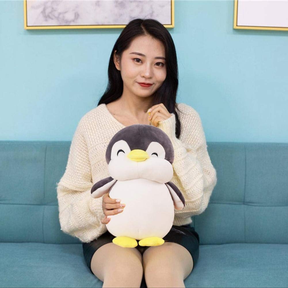 Penguin plush toy held for size reference